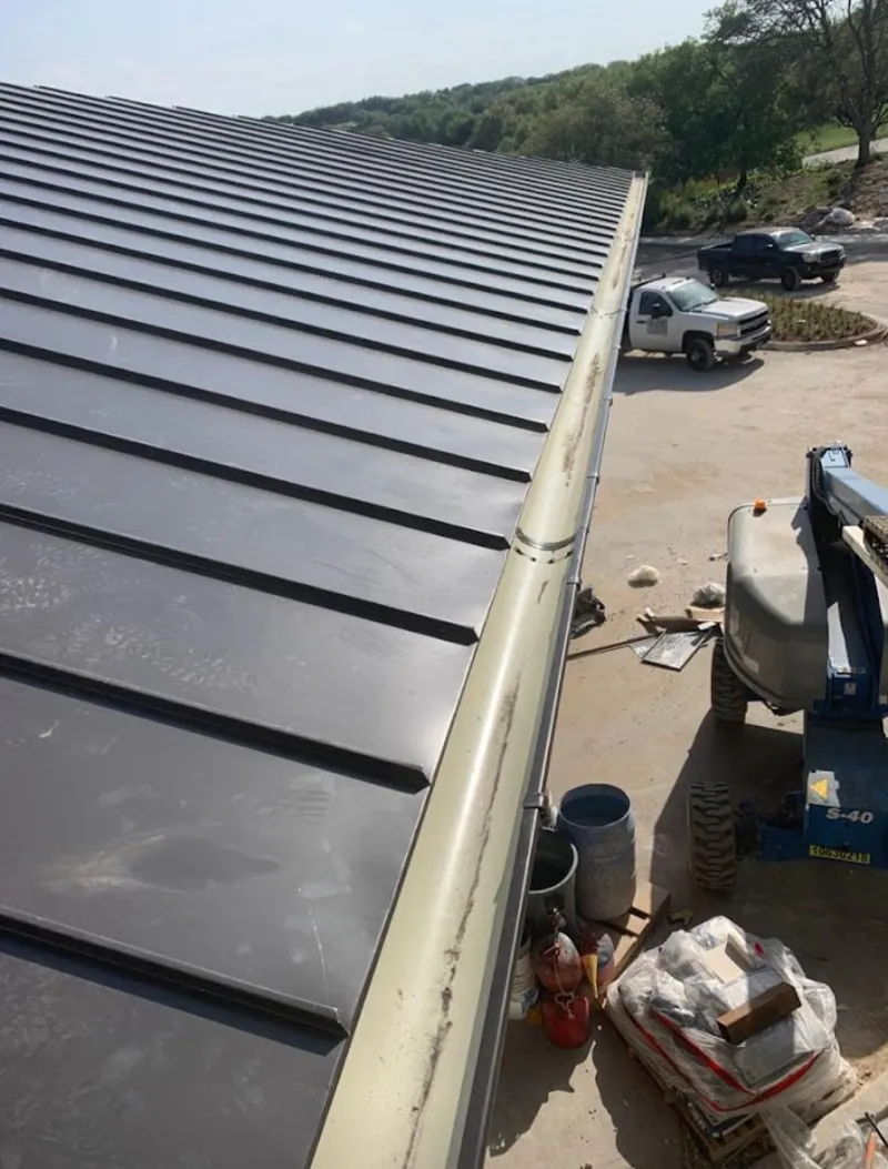 Standing seam panel and gutter detail on a metal roofing jobsite in Topsfield